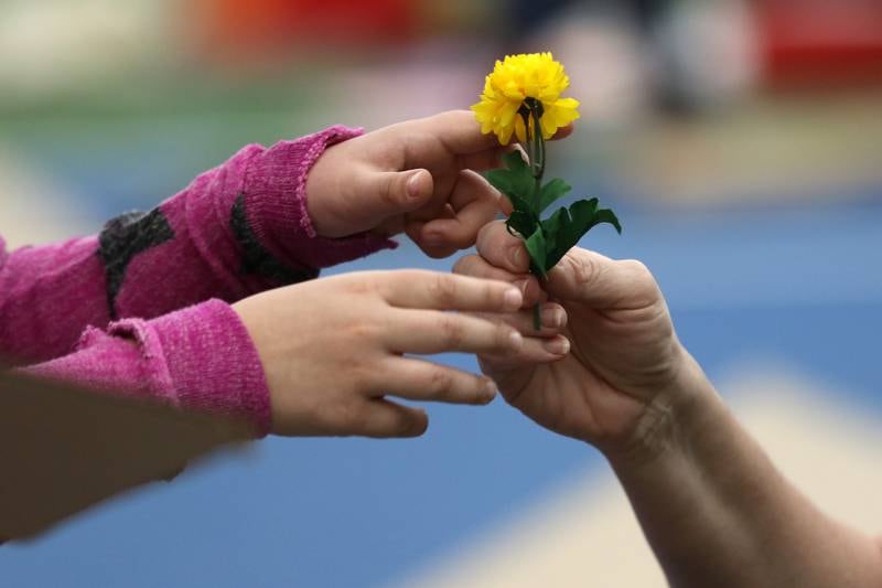 Lexie Benton of McHenry, left, reaches out for a flower cut for her by her aunt Heather Bechtel of Crystal Lake for the flower pot decorating their cardboard camper during the annual Forts on the Courts event held by the Crystal Lake Parks District on Saturday, March 13, 2021 at The Racket Club in Algonquin. Their design was voted to win first place in the contest. Seventeen teams received three pieces of cardboard and one roll of duct tape to create a unique design in an hour and a half which would be voted on by all participants for two gift card prizes each valued at $50 to Lou Malnati's and the Crystal Lake Parks District. Participants were also treated to a donated scoop of ice cream from Baskin Robbins in Crystal Lake at the end of the event.