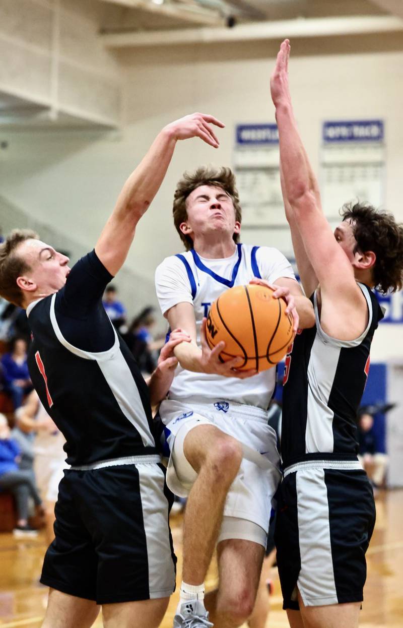 Princeton senior Jackson Mason fights his way through a pair of Erie-Prophetstown defenders in the first half of Tuesday's game at Prouty Gym. The visiting Panthers won 54-46.