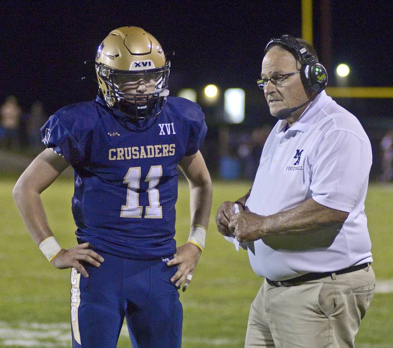 Marquette Coach Tom Jobst talks over a play with quarterback Anthony Couch during a time out Friday against Ridgewood in the 1st quarter.