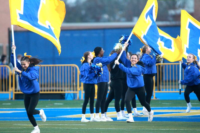 Lyons Township flag bearers run onto the field before the Class 8A second round football playoff game against York in Western Springs on Saturday, Nov. 4, 2023.