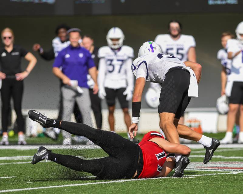 Northern Illinois University's linebacker Filip Maciorowski, left, tackles Holy Cross quarter back Cal Swanson during the second half of the game on Saturday Aug. 30, 2025, held at Huskie Stadium in DeKalb.