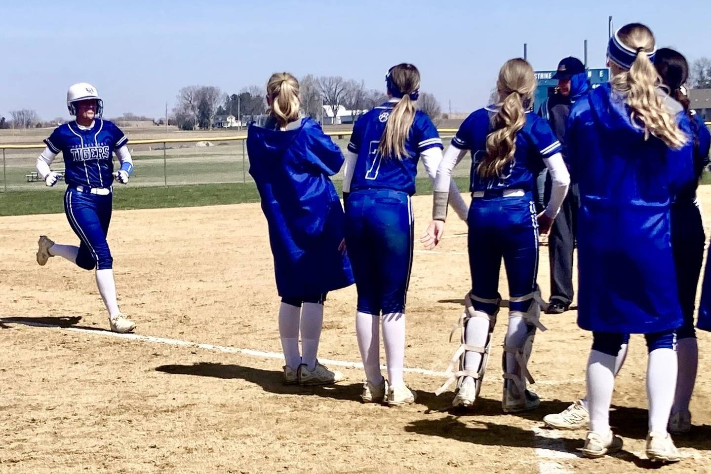 Princeton's Keely Lawson finds the welcome home party after belting a fifth-inning home run in Saturday's game at Little Siberia Field. The Tigresses beat Plano 6-1.