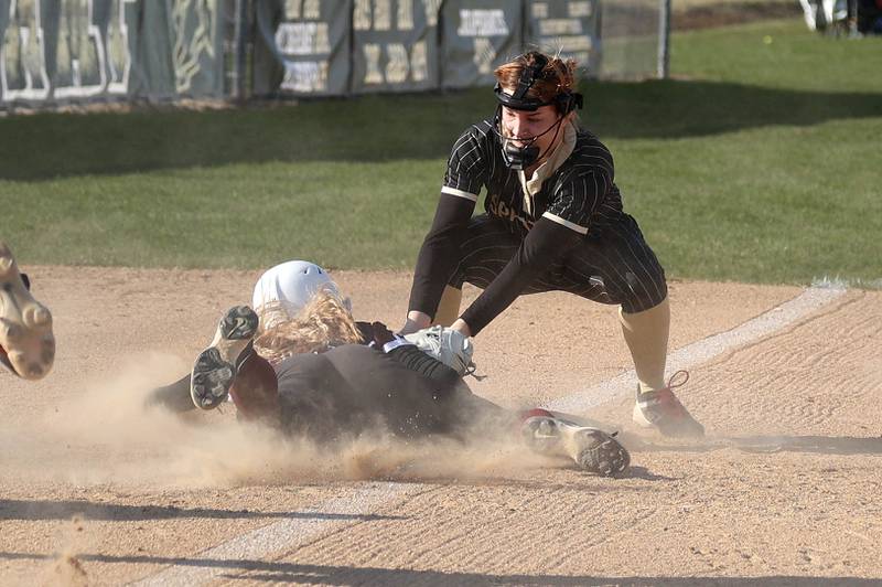 Sycamore's Ema Durst puts the tag on Marengo's Kylee Jensen as they throw behind her Friday, April 11, 2025, during their game at Sycamore High School. Jensen was safe on the play.