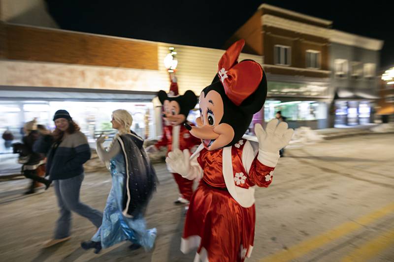 Disney characters Minnie, Mickey and Elsa visit revelers  Friday, Dec. 5, 2025, to Dixon’s Christmas Walk.