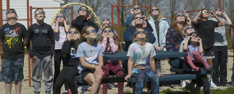 Students and faculty gather on the playground Monday, April 8, 2024, at Deer Park School in rural Ottawa to view the partial solar eclipse.