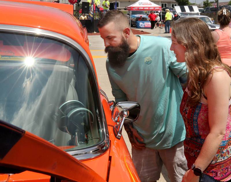 Michael and Sarah Davis, from Sycamore, look inside one of the cars Saturday, June 14, 2025, at the Flag Day Car Show in the Hy-Vee parking lot in Sycamore.