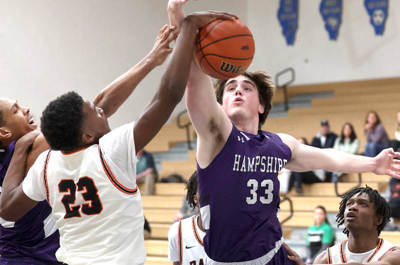 Hampshire's Sam Ptak and DeKalb's Davon Grant go after a rebound Friday, Feb. 24, 2023, during the Class 4A regional championship game at St. Charles North High School.