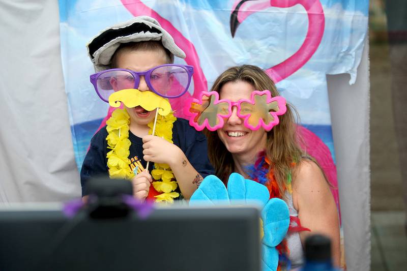 Aidan Gagalski, 6, and mom Laura Gagalski pose for a photo in the photo booth at Sycamore Library's first beach party on Friday, August 1, 2014.