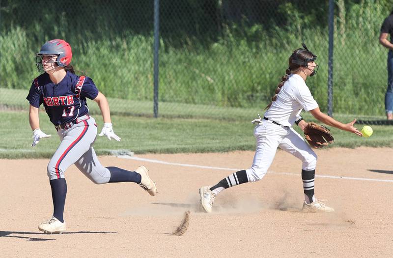 Kaneland's Angelina Campise flips the ball to first for the third out as Belvidere North's Rylee Koeller runs by Friday, June 3, 2022, during their IHSA Class 3A Sectional final game at Sycamore High School.