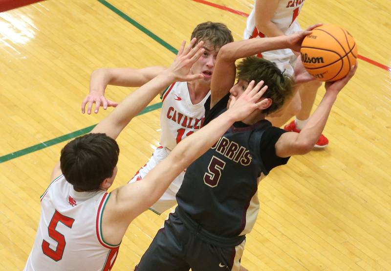 Morris's Luis Laza looks to pass the ball over the top of L-P's Jameson Hill and Erick Sotelo on Monday, Feb. 9, 2026 in Sellett Gymnasium at L-P High School.