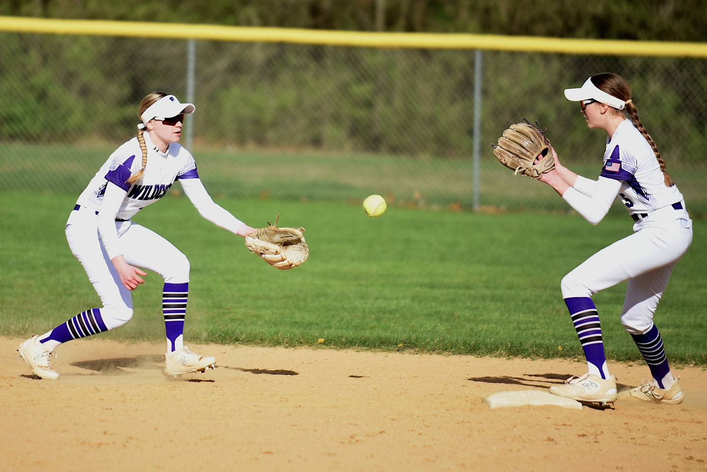 Wilmington's Nina Egizio, left, flips the ball to Keeley Walsh for a force out at second base during a home game against Herscher Tuesday, April 15, 2025.