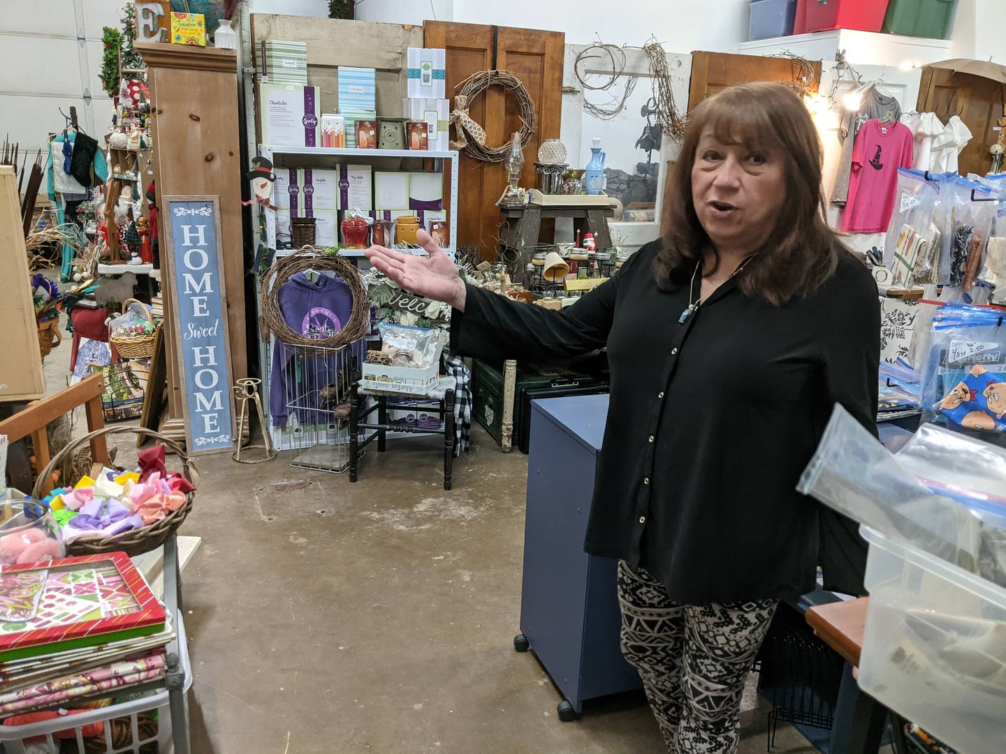 Joyce Peltz, founder of Grace Giving Joy, shows some of the items for sale in the nonprofit organization's new thrift store at 170 S. Adams St. in downtown Oswego.