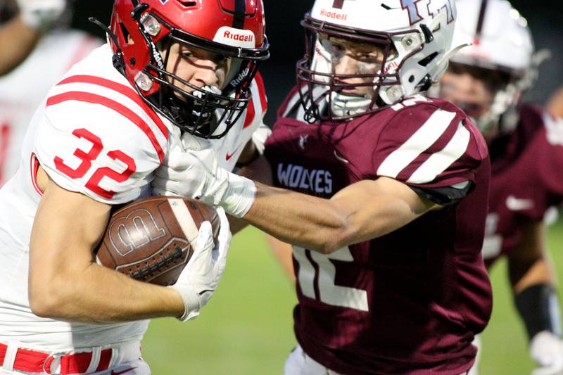 Huntley’s Reichen Dvorak, left, tries to elude Prairie Ridge’s Logan Thennes in varsity football at Crystal Lake Friday night.