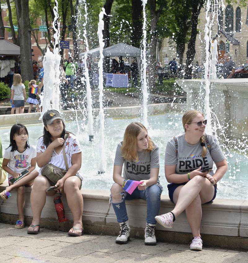 Some who attended the Ottawa Family Pride Fest found a refreshing spot to sit and watch the activities Saturday, June 11, 2022, at Washington Square in Ottawa.