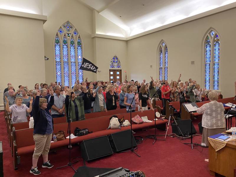 The congregation at Ottawa's Praise in the Park moved indoors following some rain to First Presbyterian Church to sing “Our God is an Awesome God” together with Brent and Michelle Mitchell.