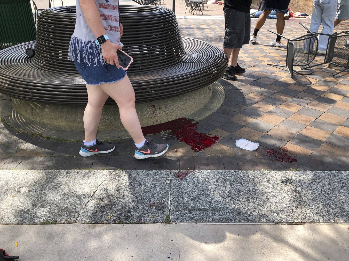Blood pooled at Port Clinton Square in Highland Park, after a shooting at a July Fourth parade, in a Chicago suburb, Monday, July 4, 2022. (Lynn Sweet/Chicago Sun-Times via AP)