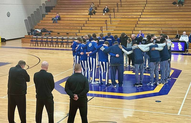 The Princeton and IMSA basketball teams hold a moment of silence for David Camp, the brother of Princeton coach Jason Smith, before their game Saturday in Sherrard. Camp was killed in a Nov. 29 auto accident.