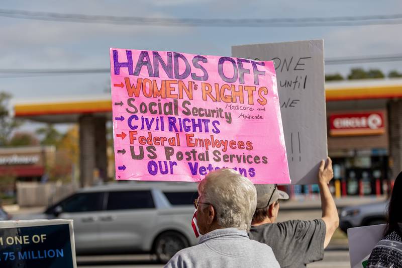 A protestor holds a ‘hands off’ sign during the No Kings Protest at Mall Loop Drive in Joliet on Oct. 18, 2025.
