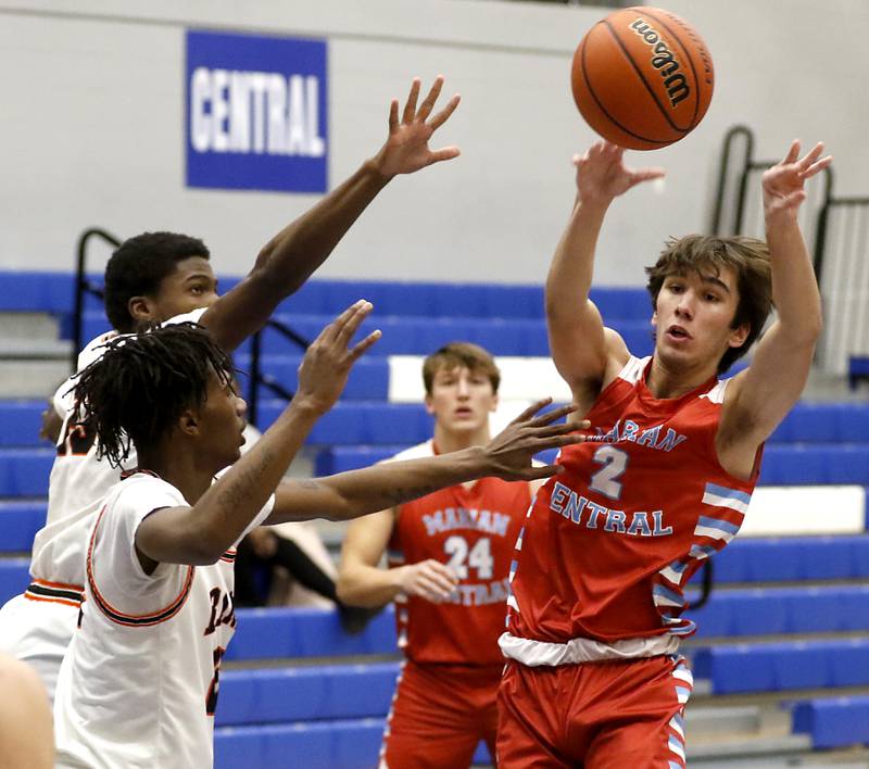 Marian Central's Jake Giangrego passes the ball as DeKalb's Davon Grat (left) and Darell Island apply pressure during a Central High School’s Dr. Martin Luther King, Jr., Boys Basketball Tournament game Friday, Jan. 13, 2023, at Central High School in Burlington.