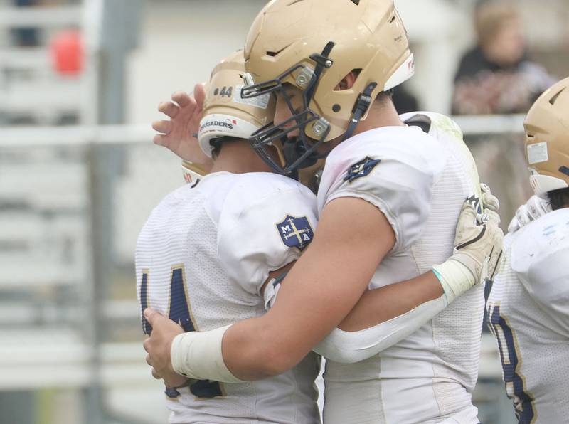 Marquette's Blayden Cassel hugs teammate Marcus Baker after loosing during the Class 1A playoff game on Saturday, Nov. 1, 2025 at Gibson City-Melvin-Sibley High School.