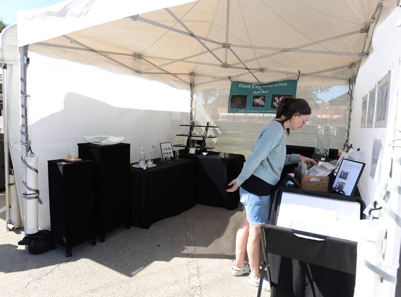 Michelle Webster of La Grange looks at the glass art of Cecile Derel of Chicago during the LaGrange Art Festival Saturday, Sept. 9, 2023.