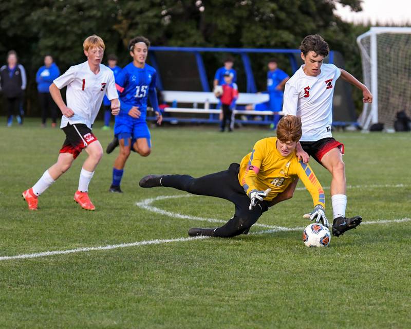 Hinckley-Big Rock’s goalkeeper dives for the ball for a save during the first half of the game as he is defended by Indian Creek Logan Schrader, 5, on Monday Sept. 26th at Hinckley-Big Rock High School.