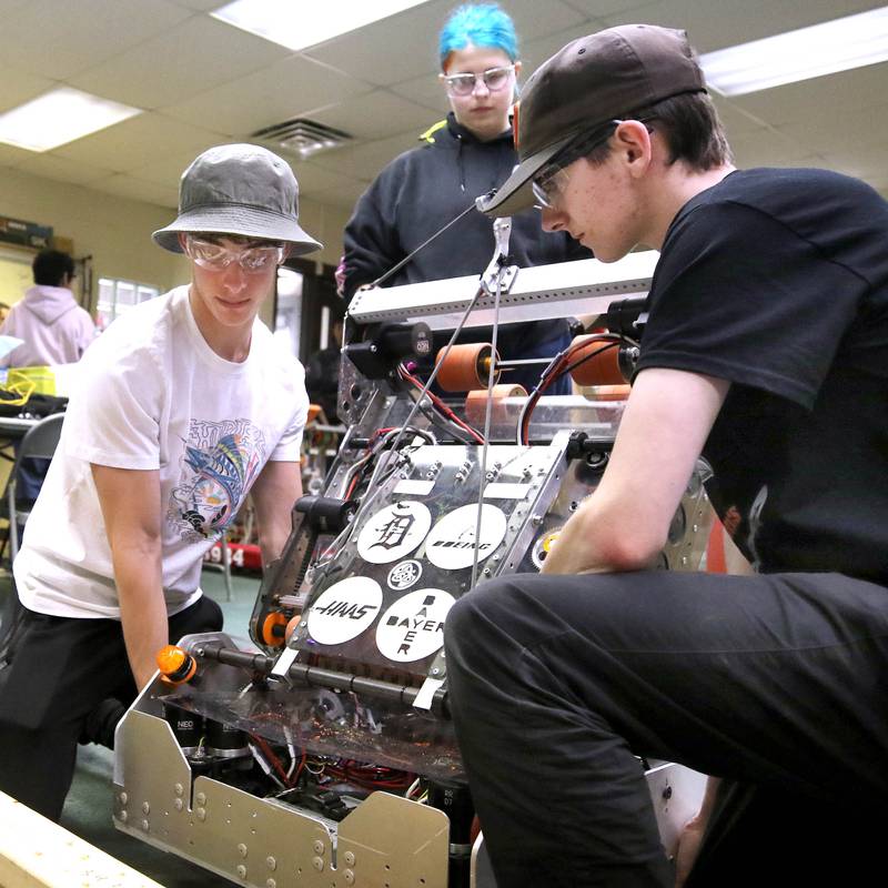 Nathan Tumminaro, (left) a junior at DeKalb High School, and Blake Bollow, a senior, carefully move their team’s robot during a Crowbotics team meeting Tuesday, April 10, 2024, at Huntley Middle School in DeKalb. Crowbotics is DeKalb High School’s robotics team who has qualified to compete in the FIRST Robotics Competition World Championship held in Houston, Texas April 17-20.
