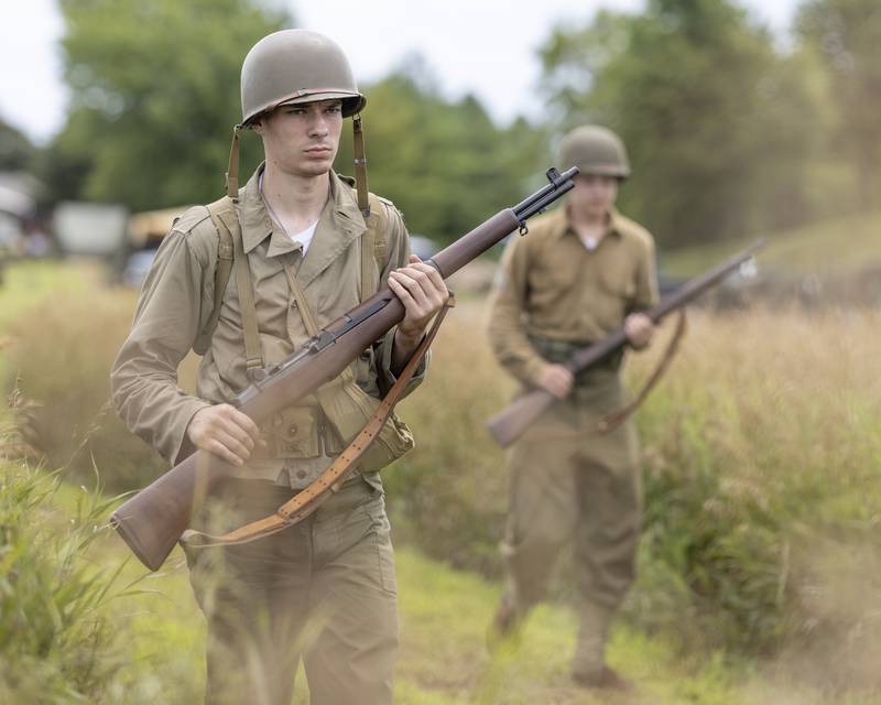 American soldier reenactors patrol the countryside in search of enemy German troops in a simulated battle Sunday, July 14, 2024, during the Ottawa Military Show in rural Ottawa.