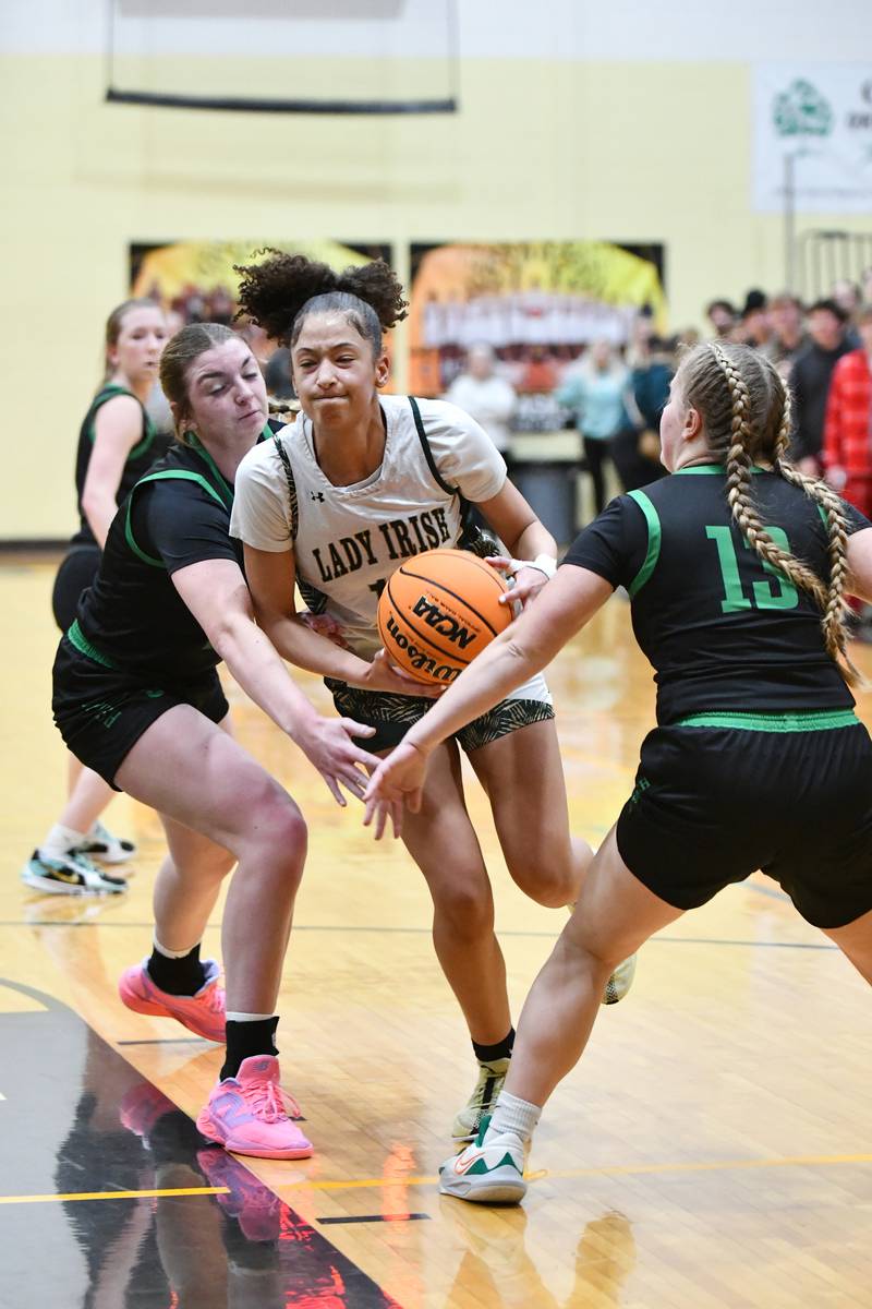 Bishop McNamara's Trinitee Thompson drives the lane under pressure from Seneca defenders during the Fightin' Irish's 51-30 victory over Seneca in the IHSA Class 2A Herscher sectional semifinal on Tuesday, Feb. 25.