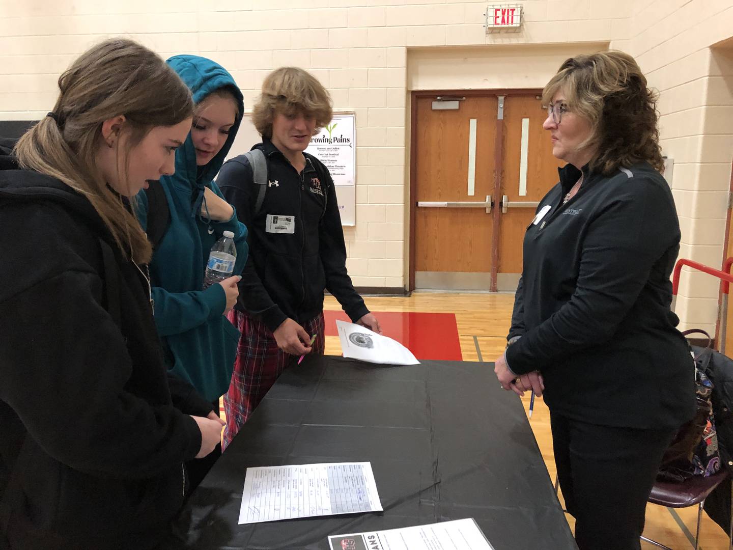 Aiden Eickelmann, Addison McVicar and Allie Moran chat with Mary Caporale during the Game of Life at Huntley High School Nov. 30, 2023