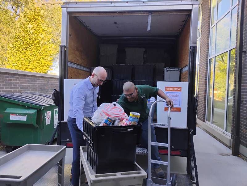 St. Charles District 303 Superintendent Paul Gordon and employee Isidro Duarte begin unloading the first truckload of food donated to the St. Charles Public Library's Community Cabinet. Gordon challenged every student and teacher to bring in one nonperishable food item on Friday, Oct. 31.