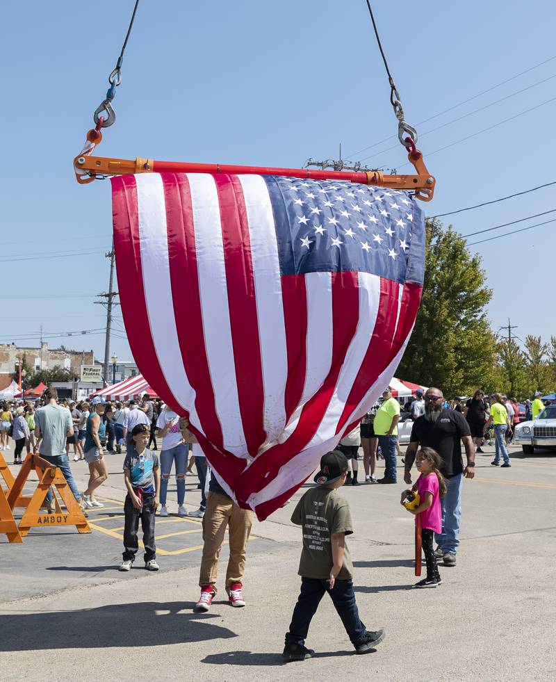 Working with a remote control, Destiny Davis (right), 7, helps dad Tony Stein raise a flag on his tow truck Sunday, August 27, 2023 during Amboy’s Depot Days.