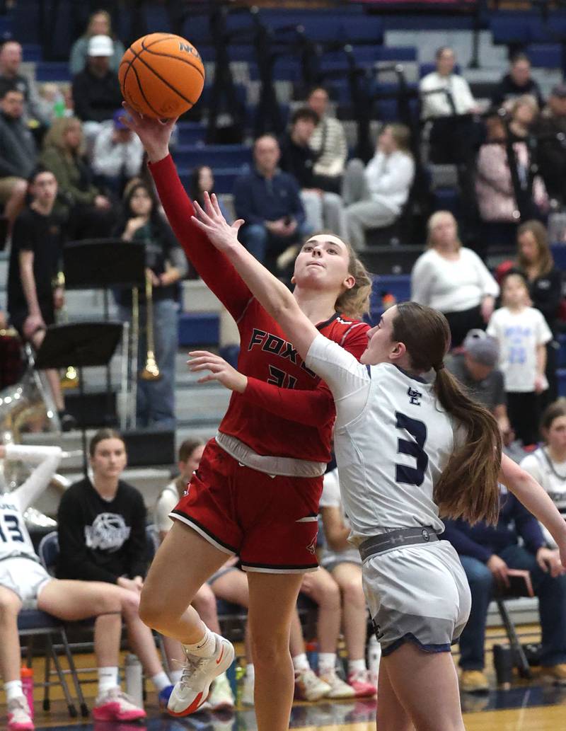 Yorkville's Johanna Pavlak goes to the basket against Oswego East's Maggie Lewandowski during their game Tuesday, Feb. 11, 2025, at Oswego East High School.