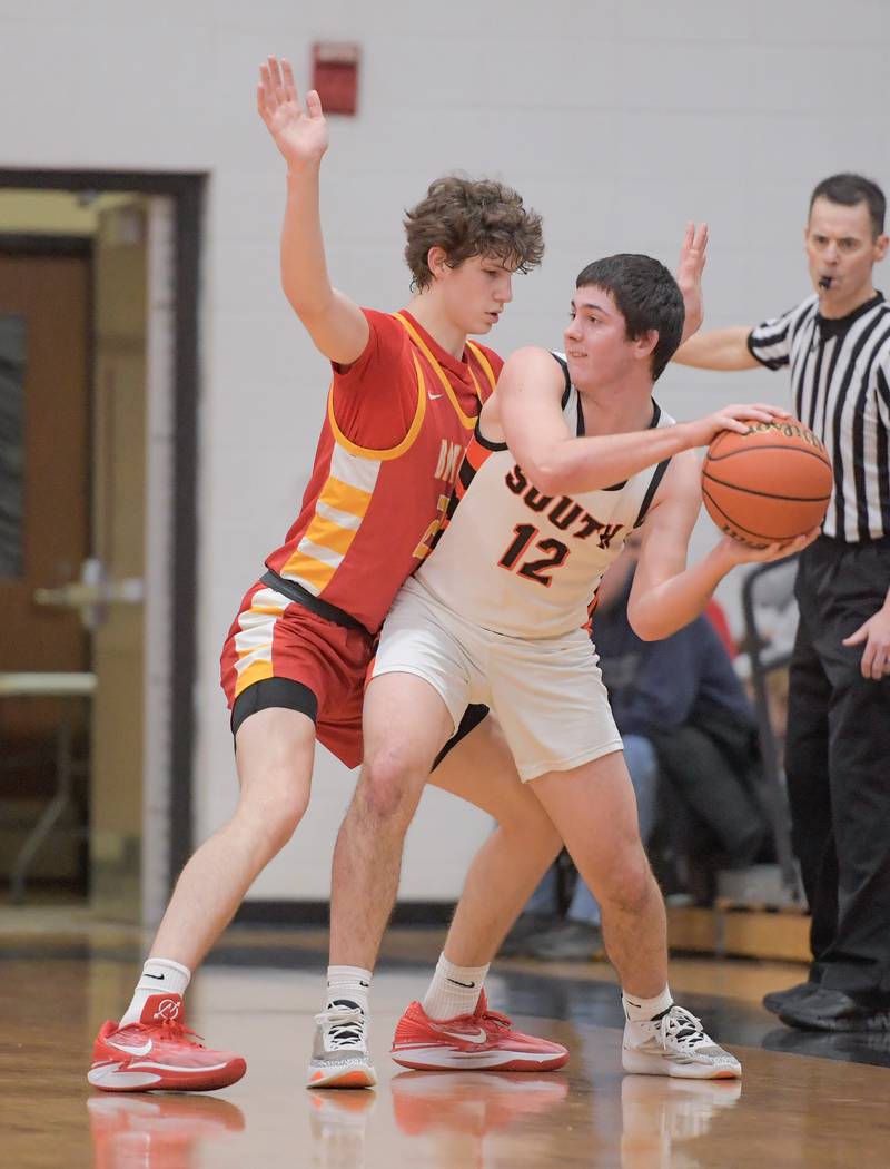 Wheaton Warrenville South's Zach Rogers (12) works to pass the ball around Batavia's Jax Abalos (23) during a game in Wheaton on Saturday, January 6, 2024.