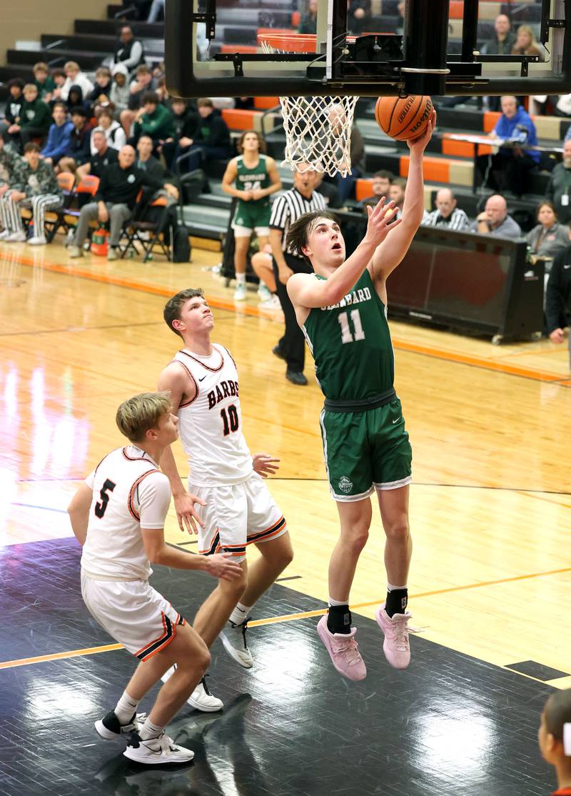 Glenbard West's Logan Brown shoots a layup in front of two DeKalb defenders during their game Tuesday, Nov. 29, 2022, at DeKalb High School.