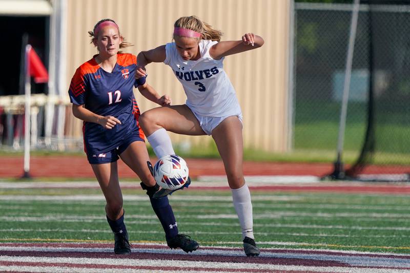 Oswego East's Anya Gulbrandsen (3) plays the ball against Oswego’s Ainsley Barnes (12) during a Class 3A Lockport Regional semifinal soccer match in May 2024 at Lockport High School in Lockport.