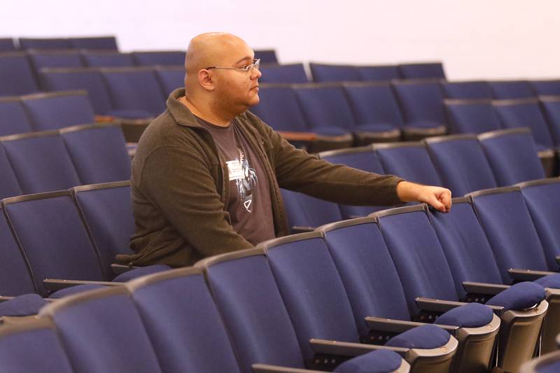 Woodstock High School graduate and composer Alex Riak listens as students perform “Unknown” on Thursday, Dec. 7, 2023, during a rehearsal for the school's “Across the Universe” concert. Riak, who graduated in 2014, and now works as a professional composer in Los Angeles created a piece for the concert.