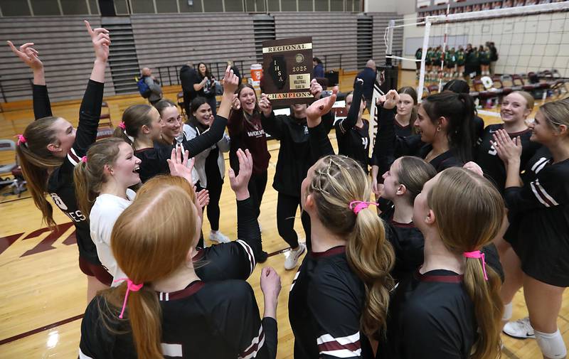 Prairie Ridge Head Coach Leah Groat lifts the trophy after talking with her team during the IHSA Class 3A Prairie Ridge Regional championship volleyball match against Crystal Lake South on Thursday, Oct. 30, 2025, at the Prairie Ridge High School in Crystal Lake.