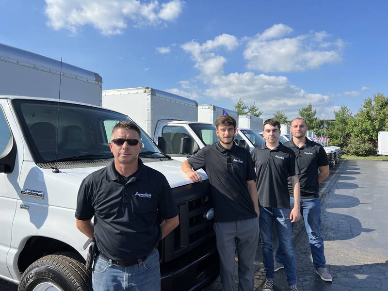 Brent M. Pennington, owner of Signature Truck Center in Crystal Lake, with three of his employees.