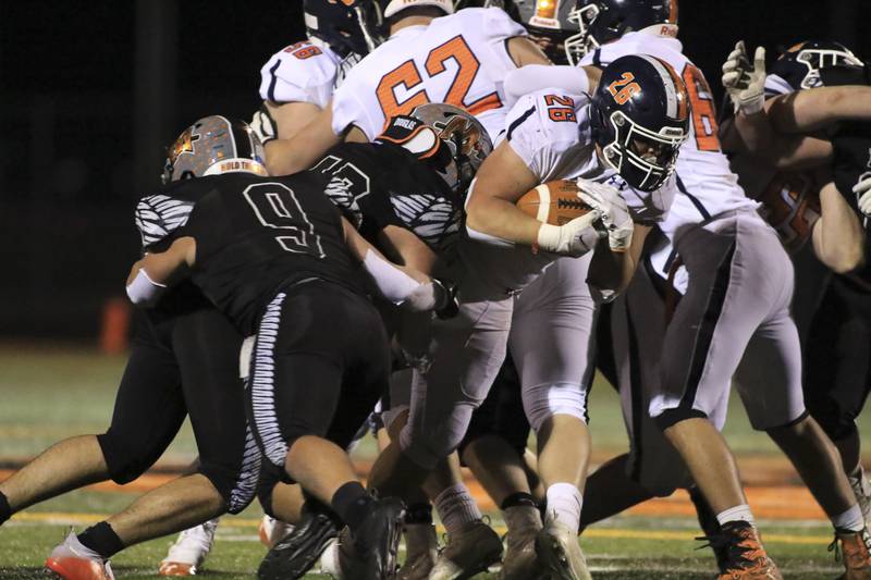 Oswego's Jacob Sergen (26) runs for tough yards during football game between Oswego at Minooka.  April 23, 2021.