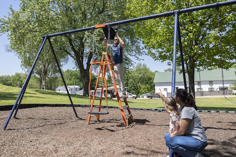 Dixon Park District’s Seth Nicklaus unveils the temporary “Sophia’s Swing” plaque Friday, May 15, 2026, above the new Expression Swing at EC Smith Park. The plaque will be given to the family when a permanent one is installed.