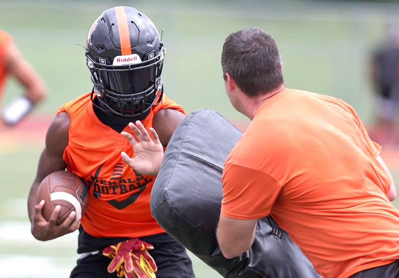 DeKalb's Ethan McCarter carries the ball Monday, Aug. 8, 2022, at the school during their first practice ahead of the upcoming season.