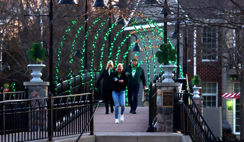 Festivalgoers make their way across the McHenry Riverwalk on Friday, March 17, 2023, to the ShamROCKS the Fox Festival in McHenry.
