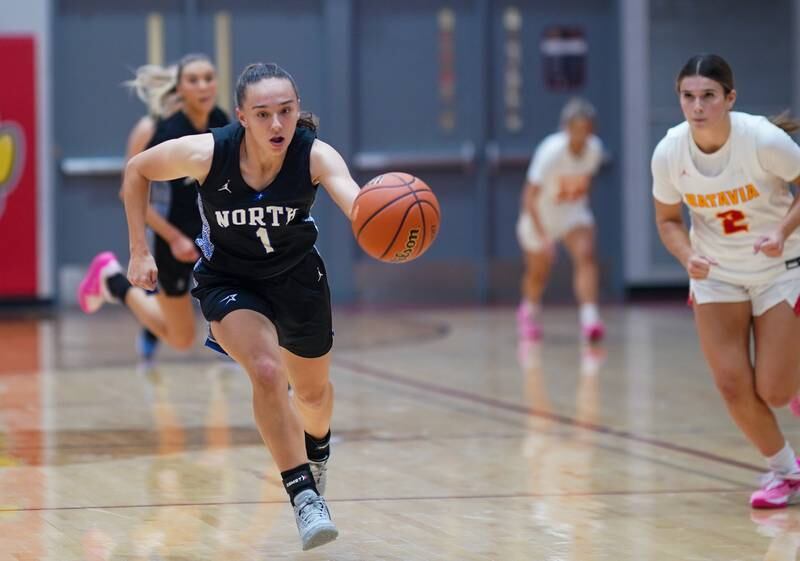 St. Charles North's Laney Stark (1) pushes the ball up the court on a steal against Batavia during a basketball game at Batavia High School on Tuesday, Dec 5, 2023.