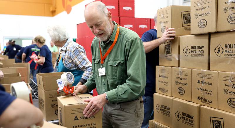 Volunteer Calvin Bloesch helps assemble holiday meal boxes on Tuesday, Oct. 29, 2024 at the Northern Illinois Food Bank in Geneva. This year marks the 25th anniversary of Northern Illinois Food Bank's Holiday Meal Box program.