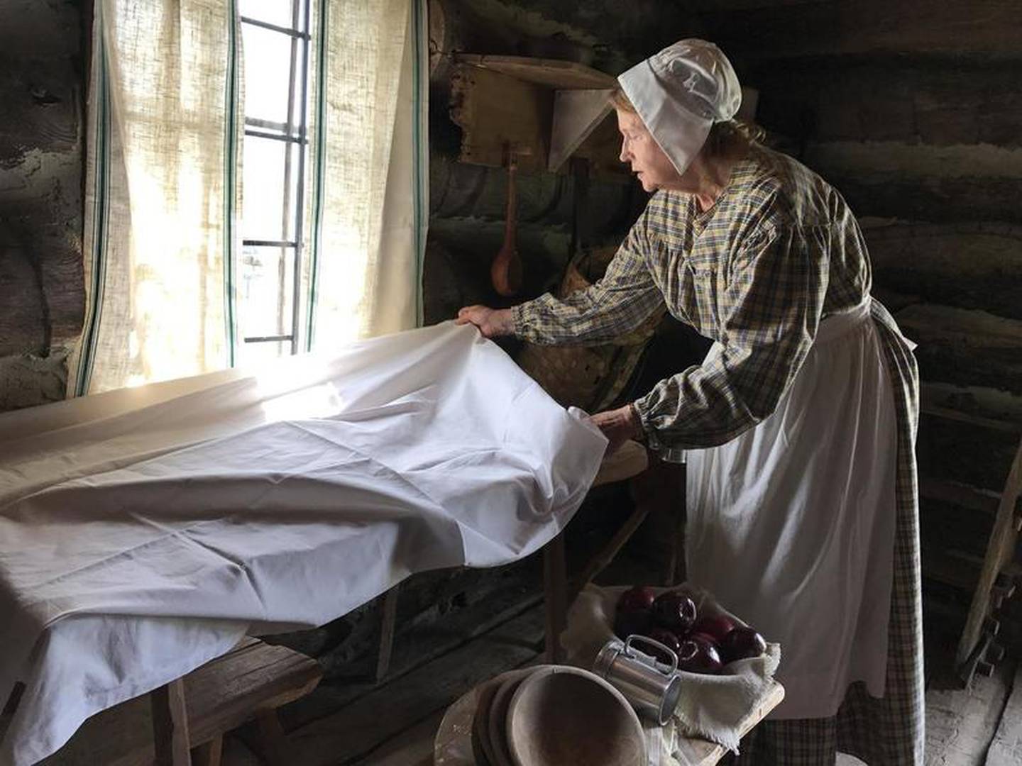 Mrs. Cragg, a 1830s settler, sets the table for her husband, Mr. Cragg and their seven children while living on the prairie of Illinois. A replica of the Cragg Cabin sits on the grounds of the Goose Lake Prairie State Natural Area in order to preserve local history. June 3, spectators visited the area for the annual Cabin Festival to learn about life in the 1800's.