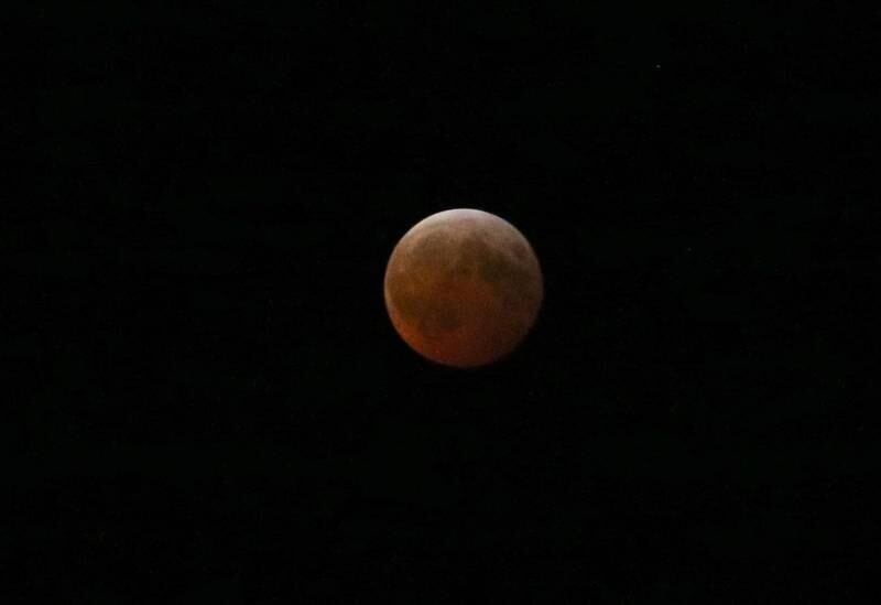 The moon gives off a red-orange glow during a total lunar eclipse on Friday, March 14, 2025 at City Hall Park in Princeton. A lunar eclipse occurs when the Sun, Earth, and Moon align so that the Moon passes into Earth’s shadow. When the Moon is within the umbra, it appears red-orange. Lunar eclipses are sometimes called “Blood Moons” because of this phenomenon. The next visible one in Illinois will not occur until March 3, 2026.