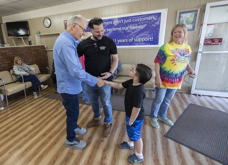 Johannes Como, 5, greets Dick Dir Monday, March 30, 2026, during Dir’s retirement party from Bill and Dick’s Barbershop. Dad Jacob was Dick’s employee for a few years and also received his first haircut from the long-time barber.