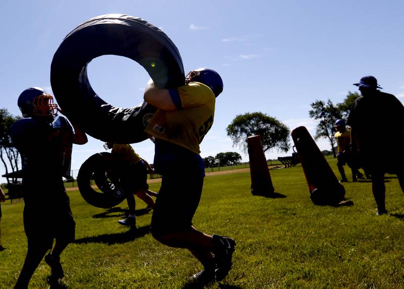 Johnsburg football players lift a donut pad as they practice tackling during summer football practice Thursday, June 23, 2022, at Johnsburg High School in Johnsburg.