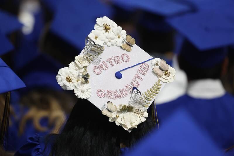 A graduate customizes their hat at the Joliet Central Class of 2023 Commencement Ceremony on Saturday, May 20, 2023, in Joliet.